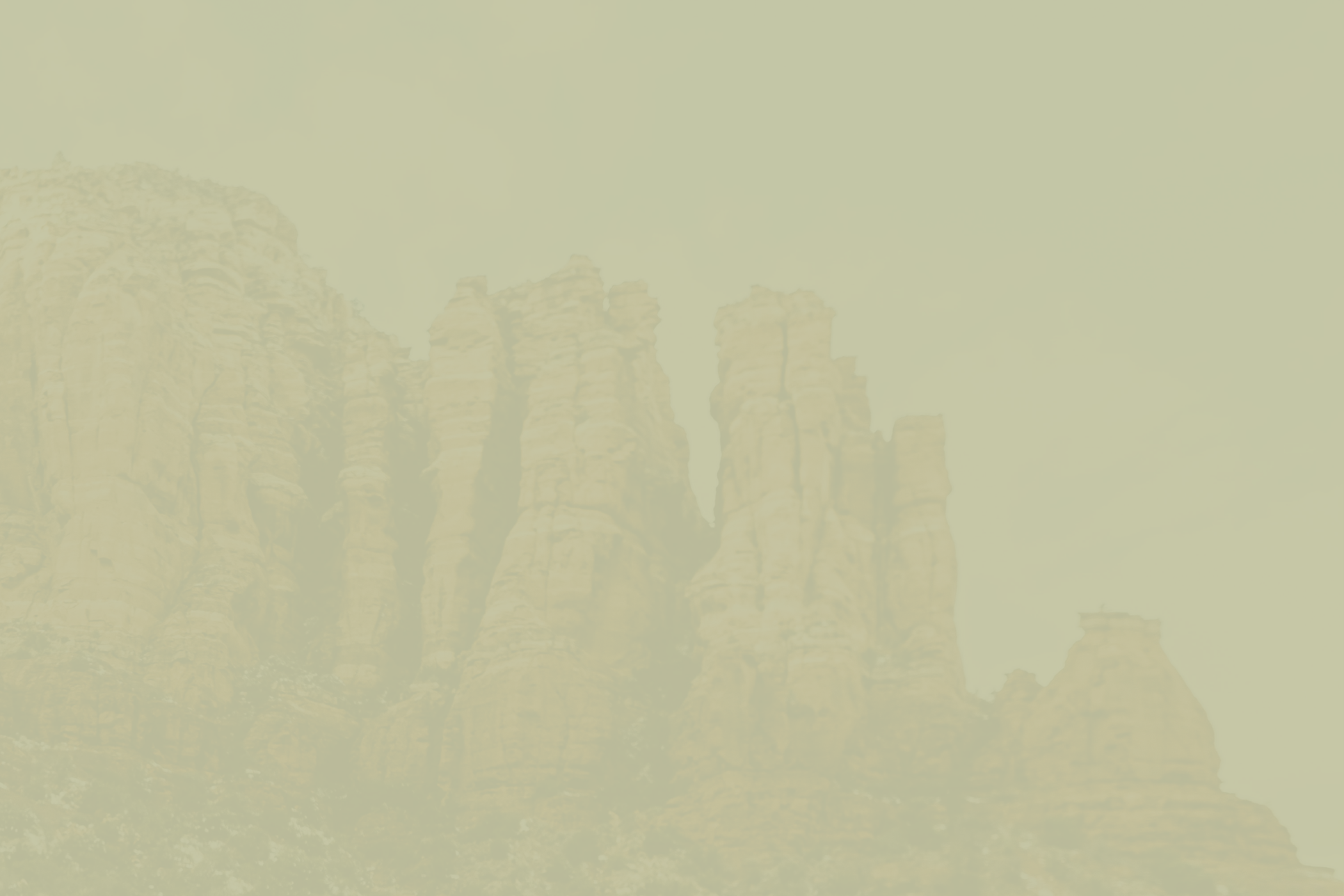 Sandstone rock formations against a pale yellow sky