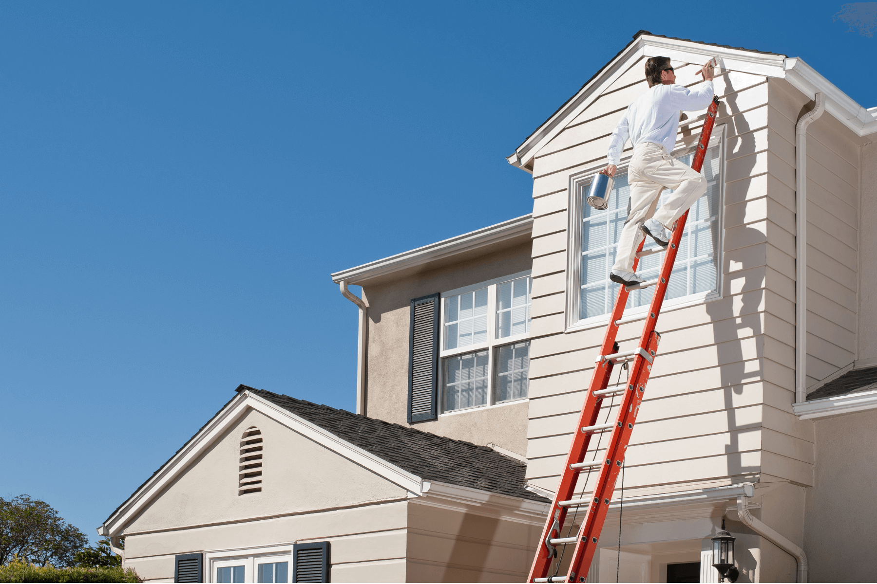 Guy on a ladder painting a house exterior trim Billings, MT