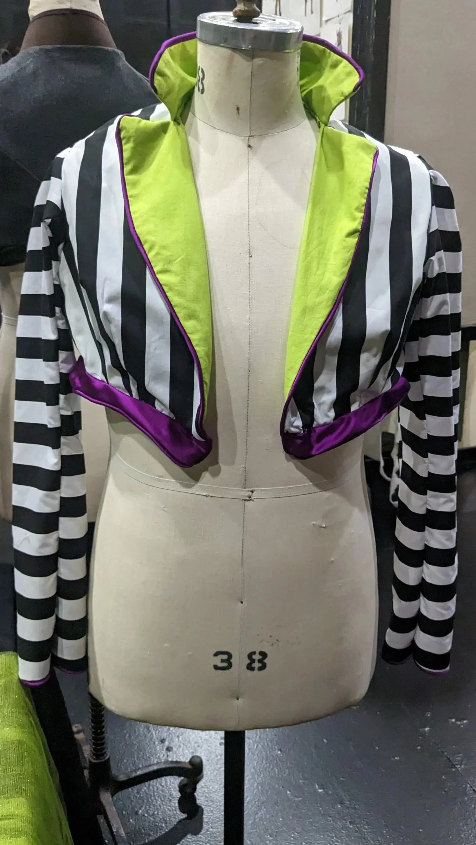 Beetlejuice inspired Spencer Jacket, constructed using altered Hamilton Spencer pattern. Materials: Neon Green Cotton Fabric- Black and White Striped Cotton Fabric- Purple Satin Fabric- Hand Made Purple Satin Piping. 
