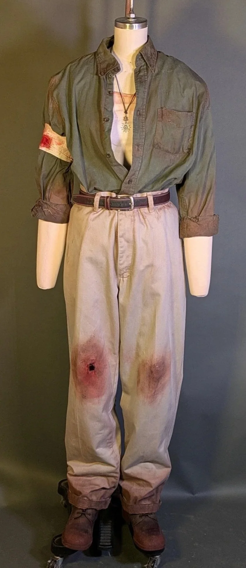 Inspired by 80's  Action-Adventure based media with an earthy, rugged palette. Materials: Pre Sourced Clothing- Brown Acrylic Paint- Faux Blood- Brown Fabric Paint- Craft Sand- Sand Paper (Distressing)- Rocks (Distressing)- Exacto Knife (Distressing)