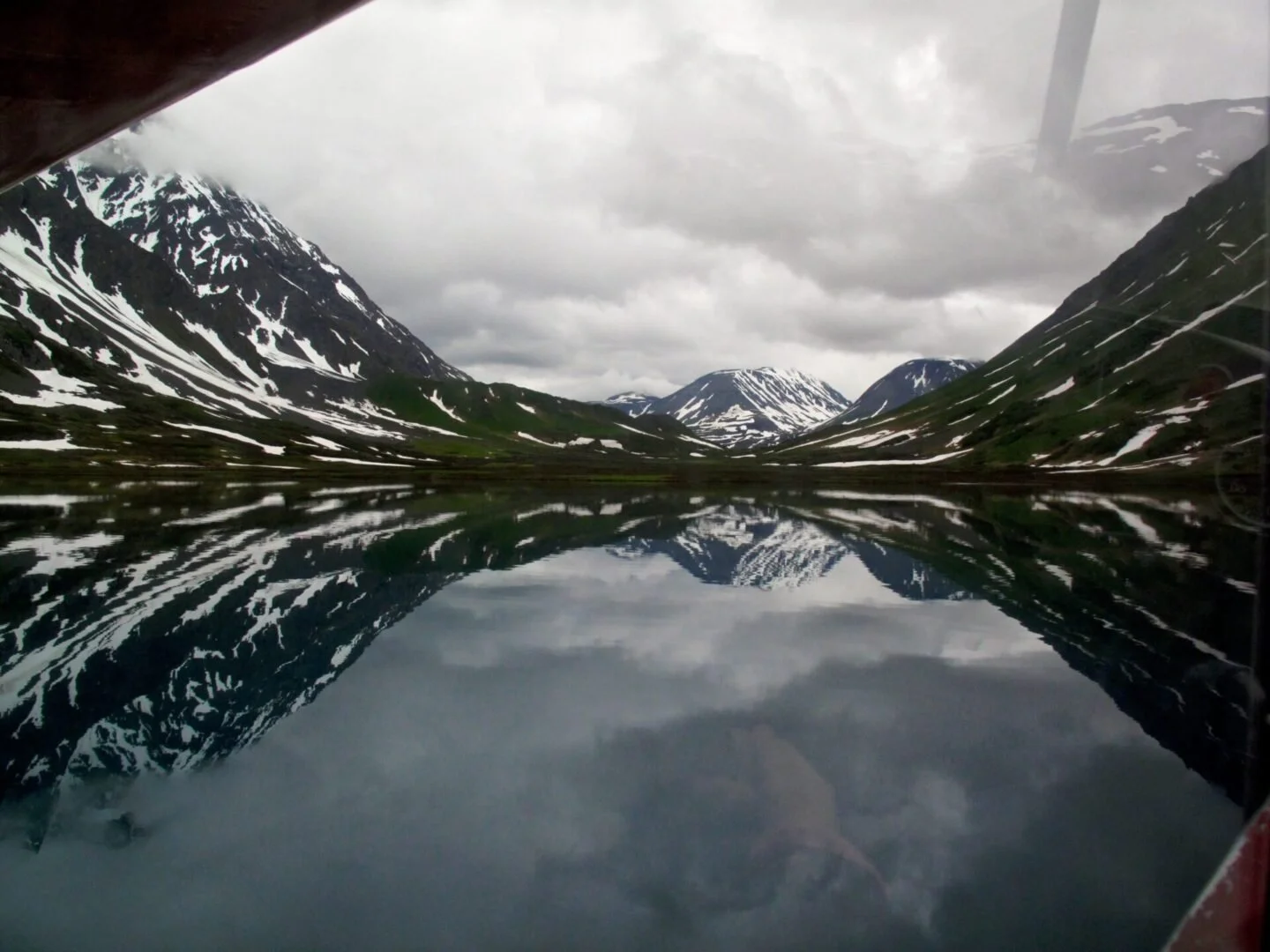 Pristine Alaska lake with mountain reflections, scenic destination during float plane training flights
