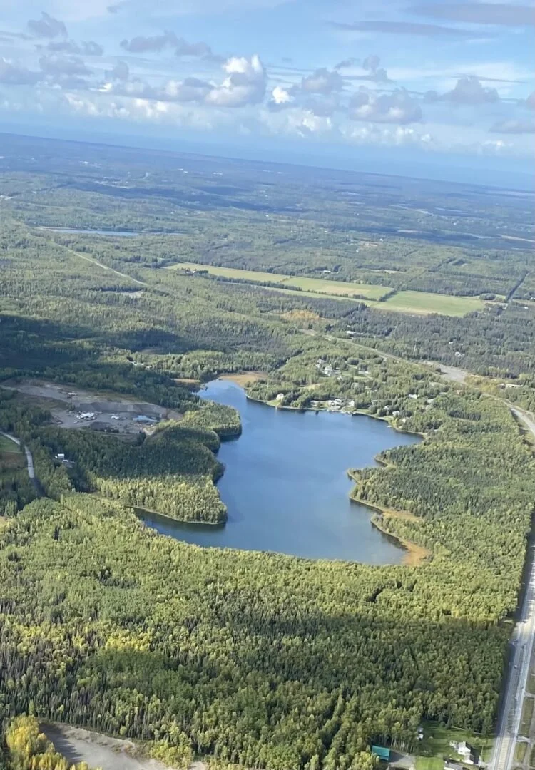 Aerial view of Alaska lake surrounded by boreal forest from float plane during training flight