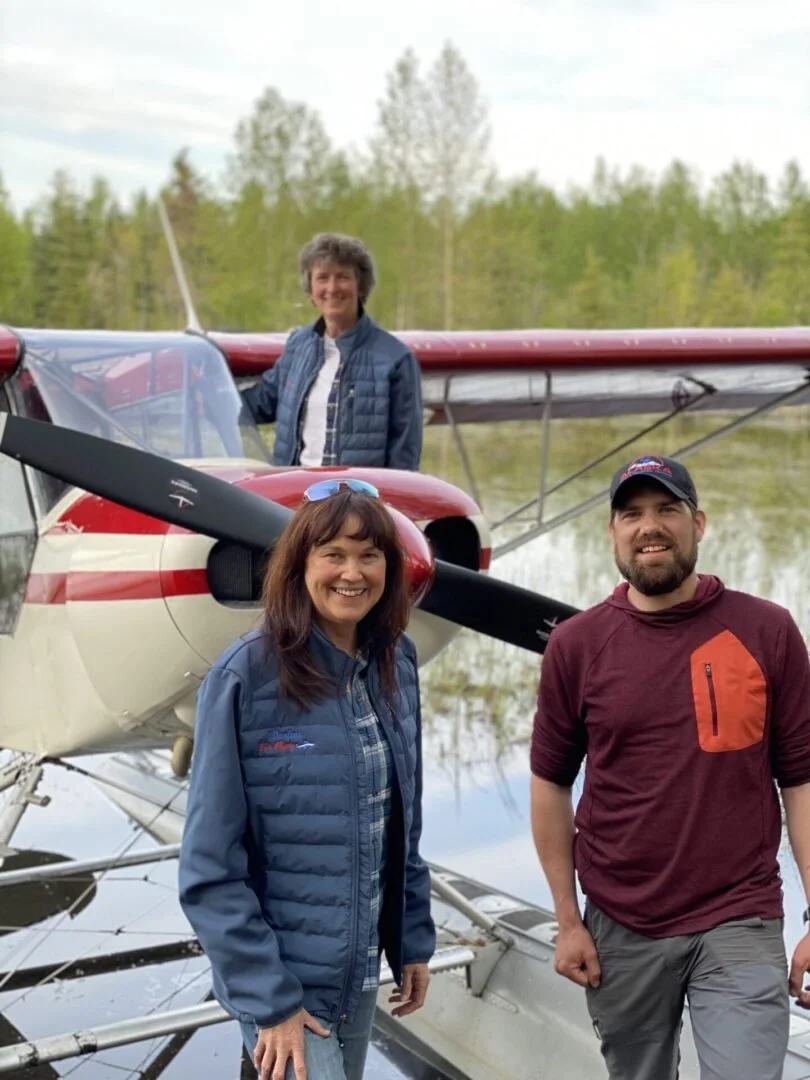 Three students and instructor in front of float plane after successful training flight Alaska