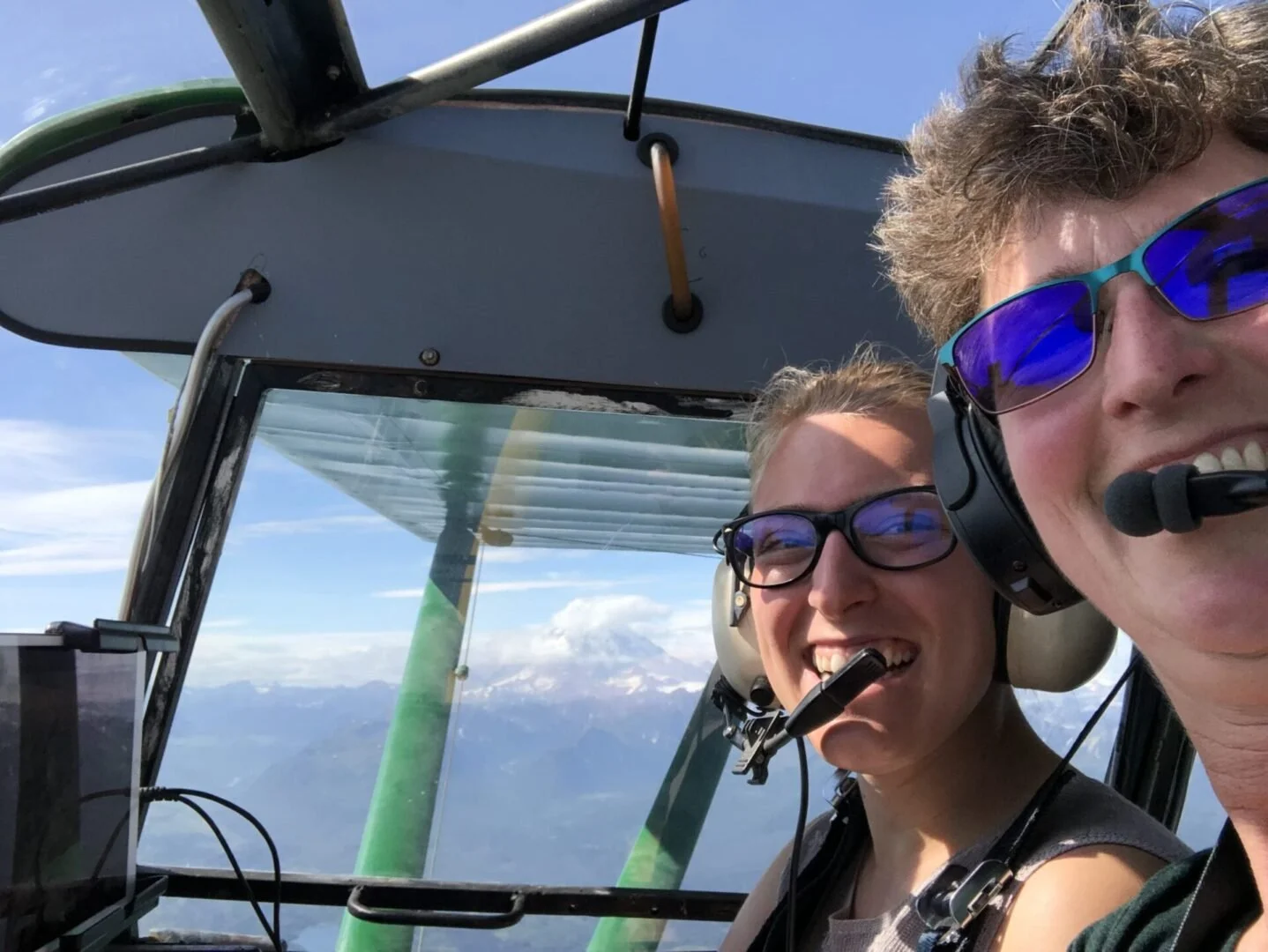 Two women pilots smiling in cockpit during float plane training at Alaska Float Training