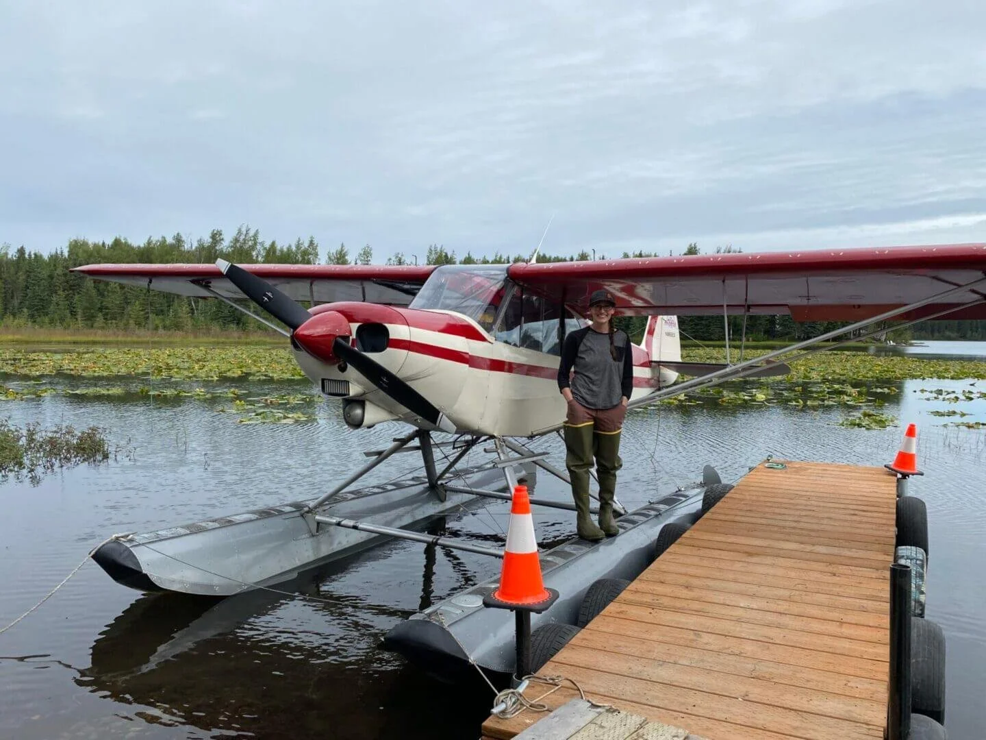 Pilot standing next to float plane on dock at Scout Lake Alaska, float plane training base