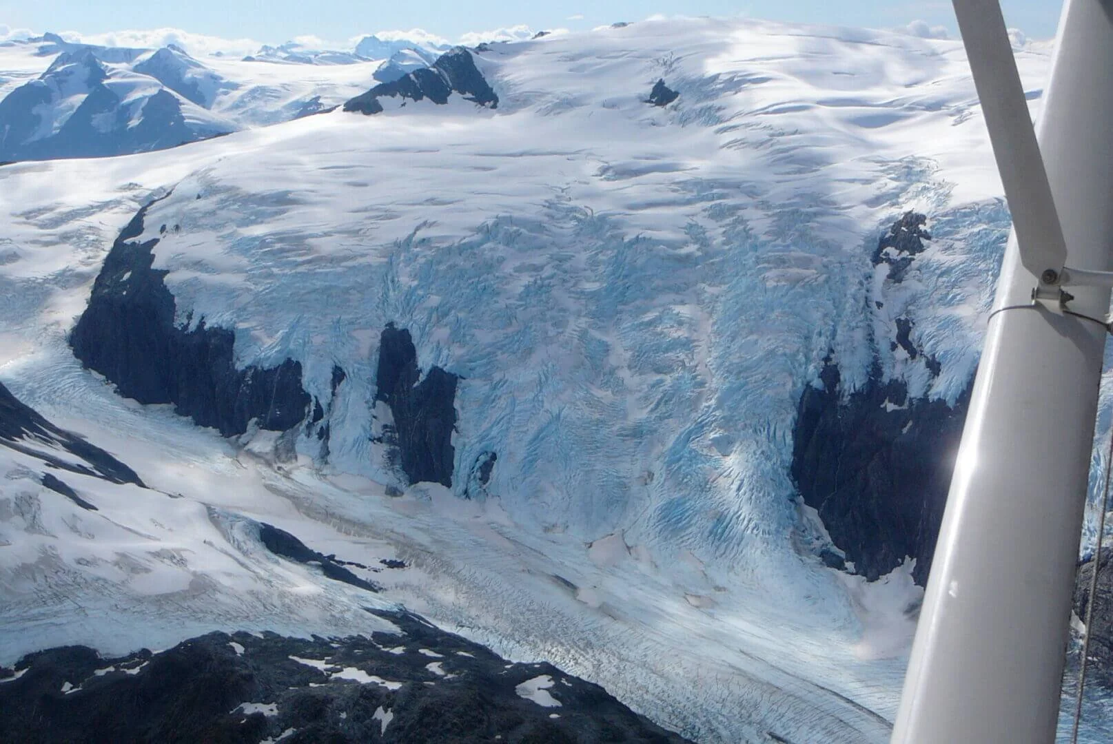 Float plane flying over Alaska mountain during advanced mountain flying course