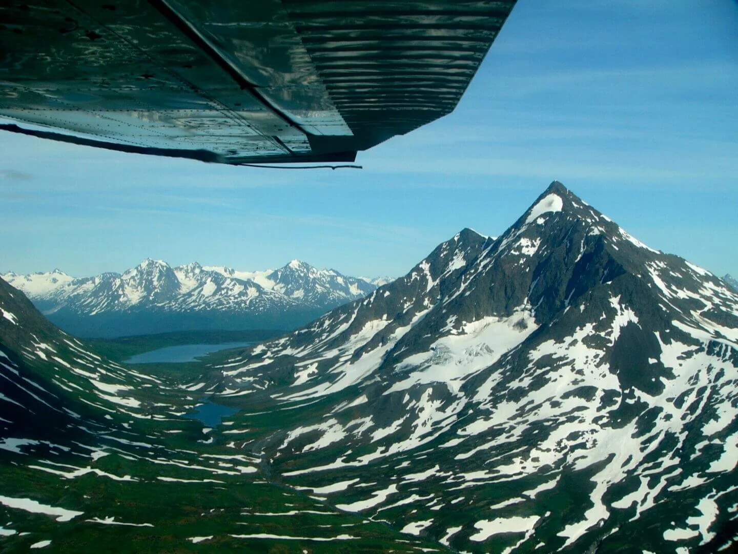 Float plane flying over Kenai Mountain range during scenic adventure flying course Alaska