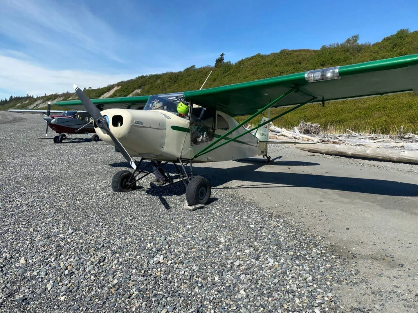 Float plane parked on gravel strip next to Alaska lake, backcountry landing practice
