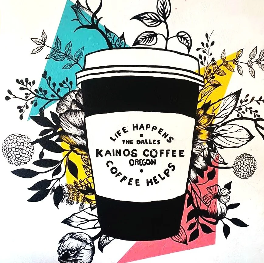 Black and white illustration of a coffee cup surrounded by colorful abstract shapes and floral patterns. The cup has text that reads, 'Life Happens, the Dalles, Kainos Coffee, Oregon, Coffee Helps'.