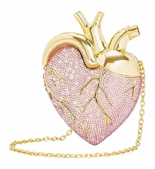 A purse shaped like a human heart, decorated with pink rhinestones and gold accents, with a gold chain strap.