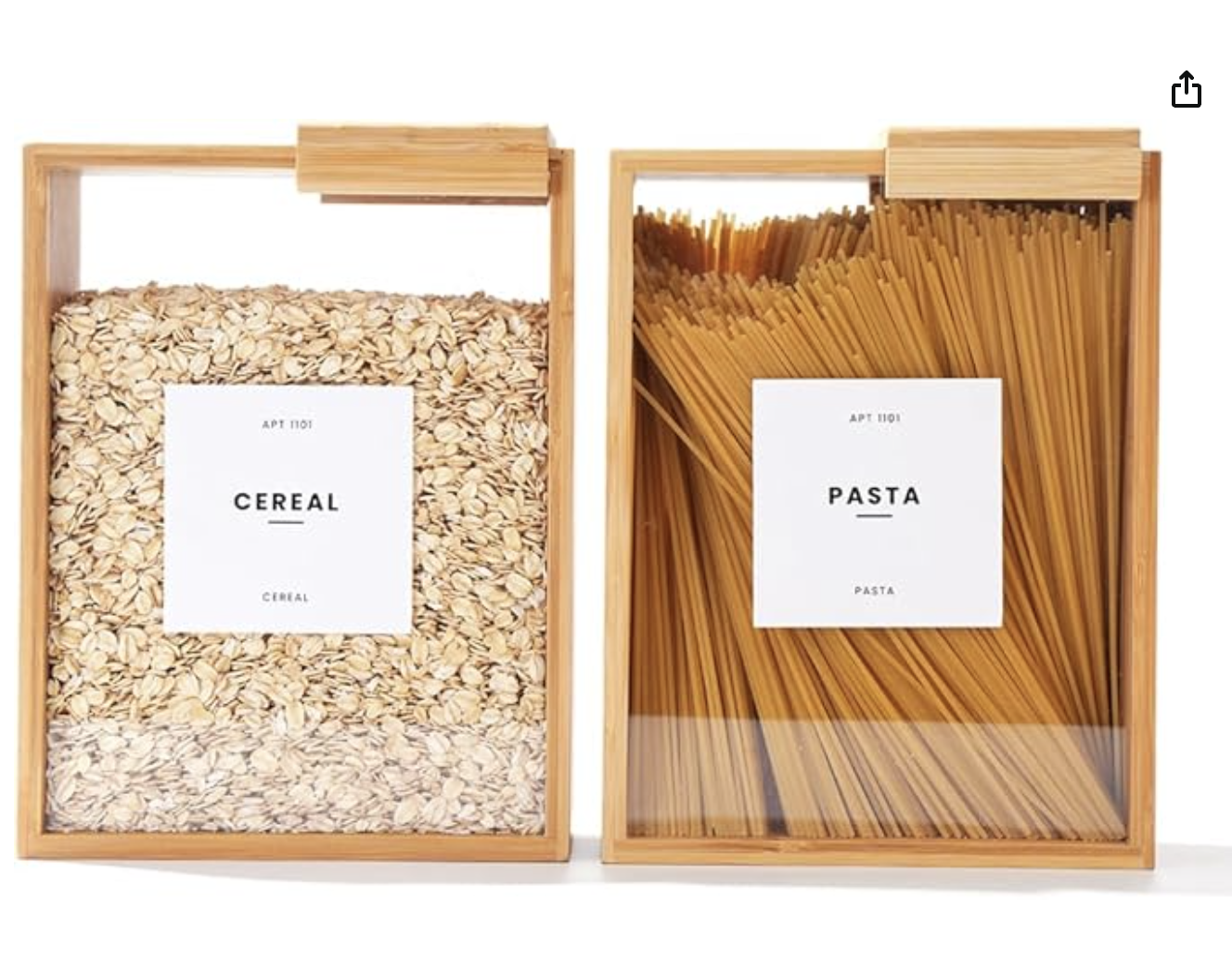 Two wooden boxes with clear covers, one filled with oats labeled as cereal and the other with uncooked spaghetti labeled as pasta.