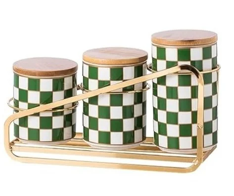Set of three cylindrical canisters with green and white checkered pattern, wooden lids, and a gold-colored metal tray with handle.
