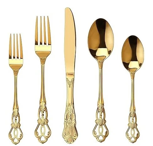 Set of five gold-colored utensils, including two forks, a butter knife, and two spoons, with ornate handles.