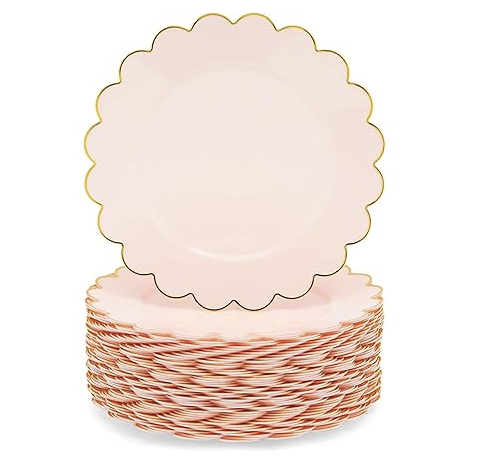Stack of pink paper dessert plates with one plate standing upright showing the scalloped edge.