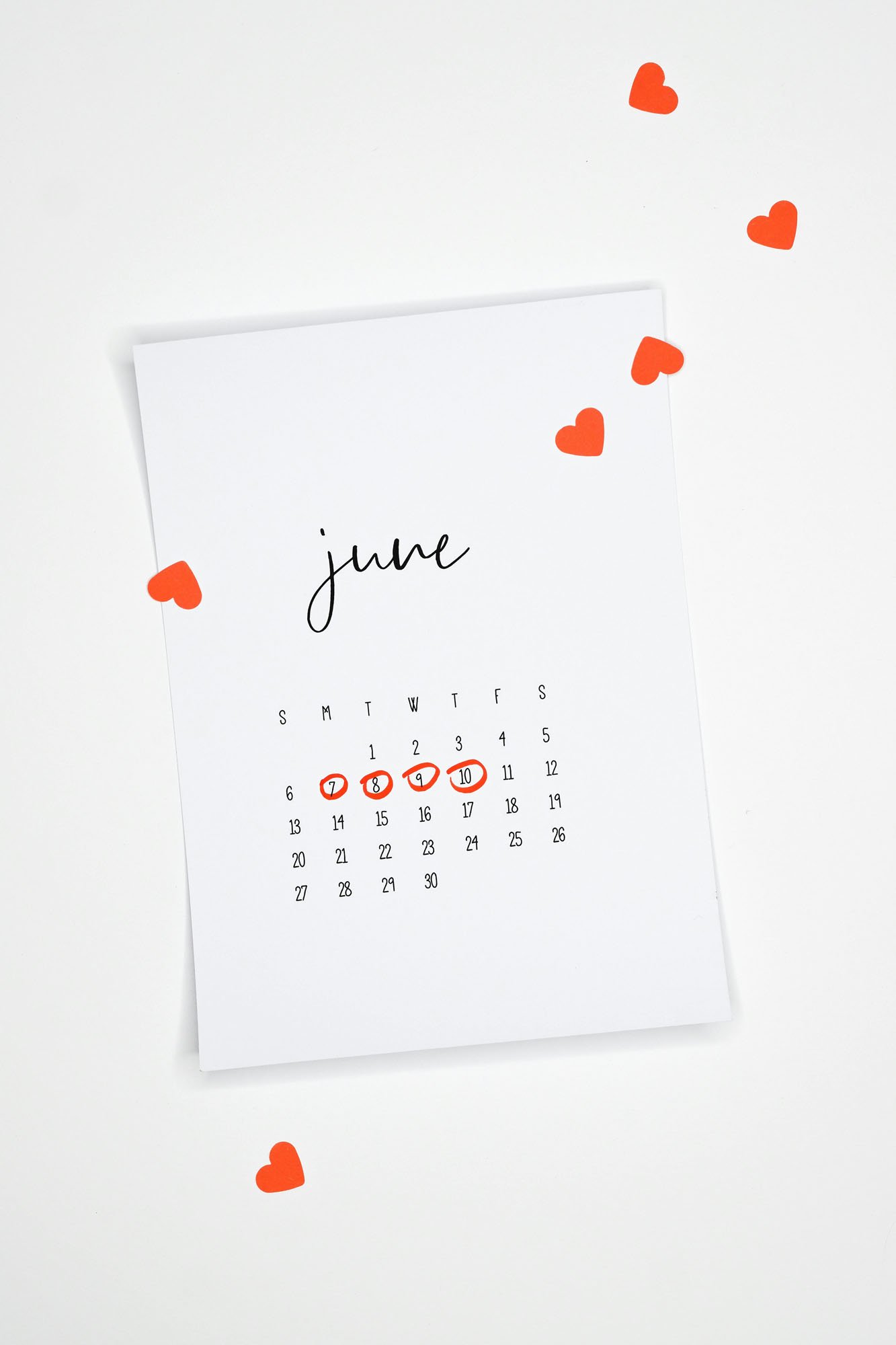 A clean June calendar with key dates highlighted in red and hearts nearby, symbolizing meaningful moments or milestones.