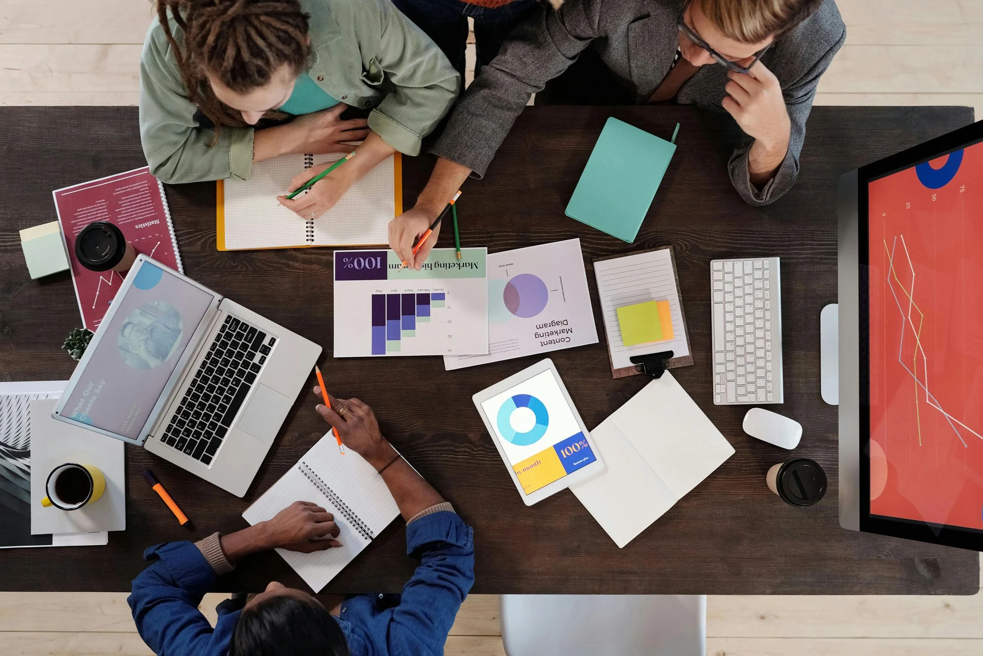 A collaborative team reviewing marketing diagrams and digital dashboards, aligning insights to guide strategic decision‑making.