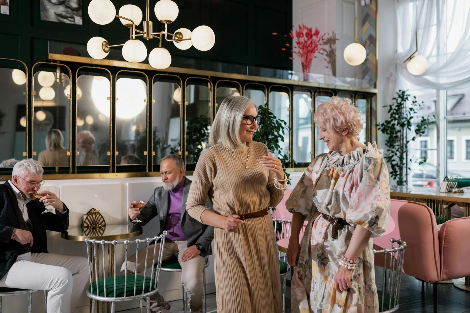 Residents in a senior living community connecting in a beautifully designed lounge, sharing conversation in a warm, hospitality‑driven environment.