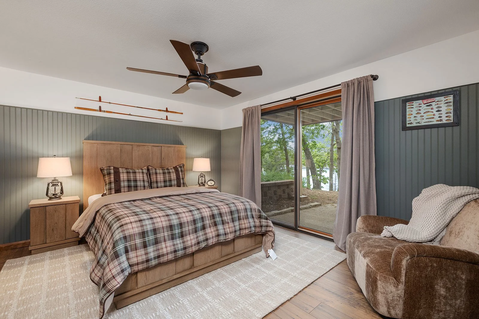 full-service-interior-design-lampe-mo-color-cohesive-home-bedroom-with-pewter-green-wall-paneling-wood-tones-doors-to-outside-collaborative-remodel.jpg