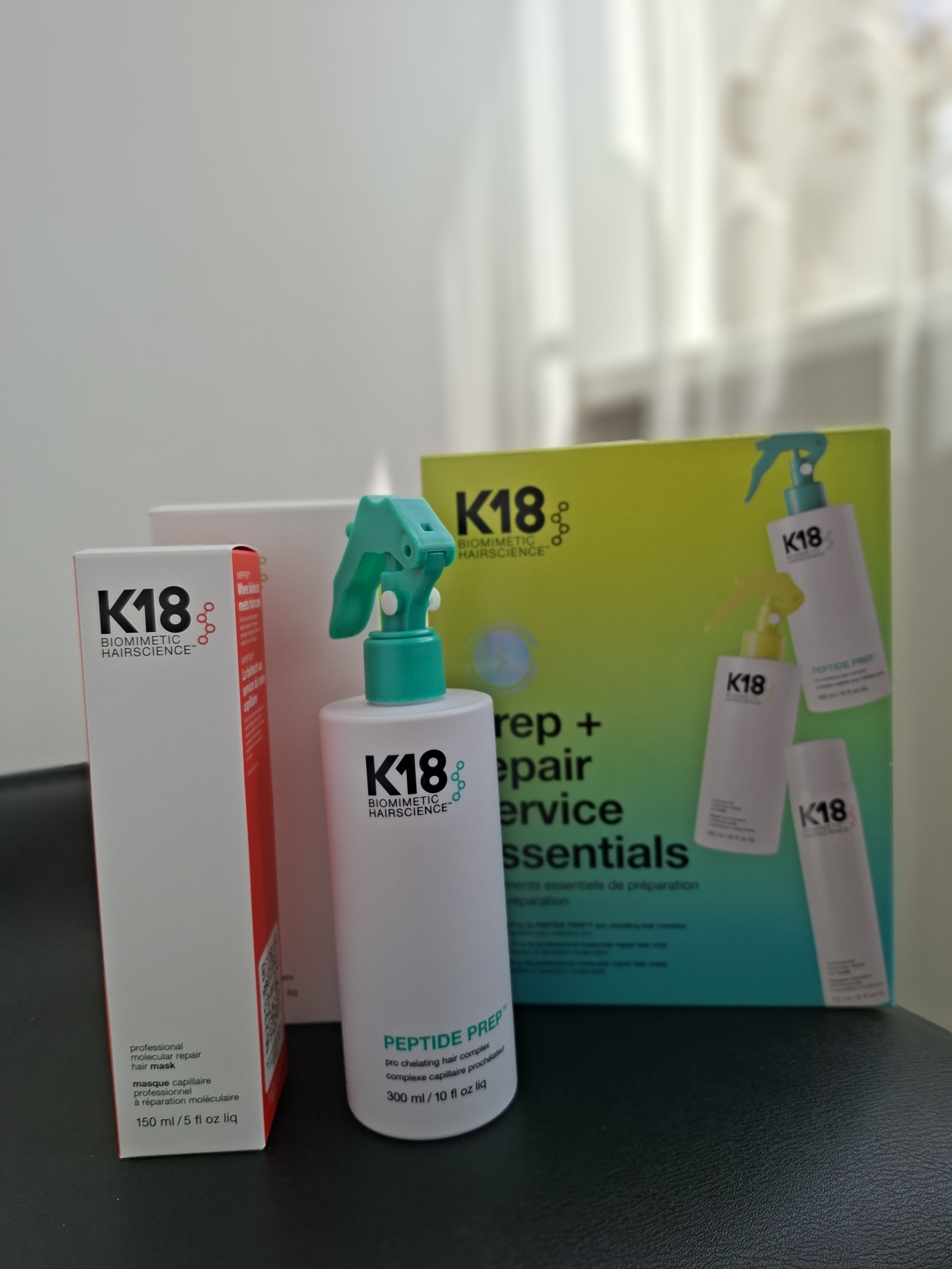 Hair care products including a bottle of Peptide Prep hair treatment and a professional hair mask, with their packaging boxes behind them.