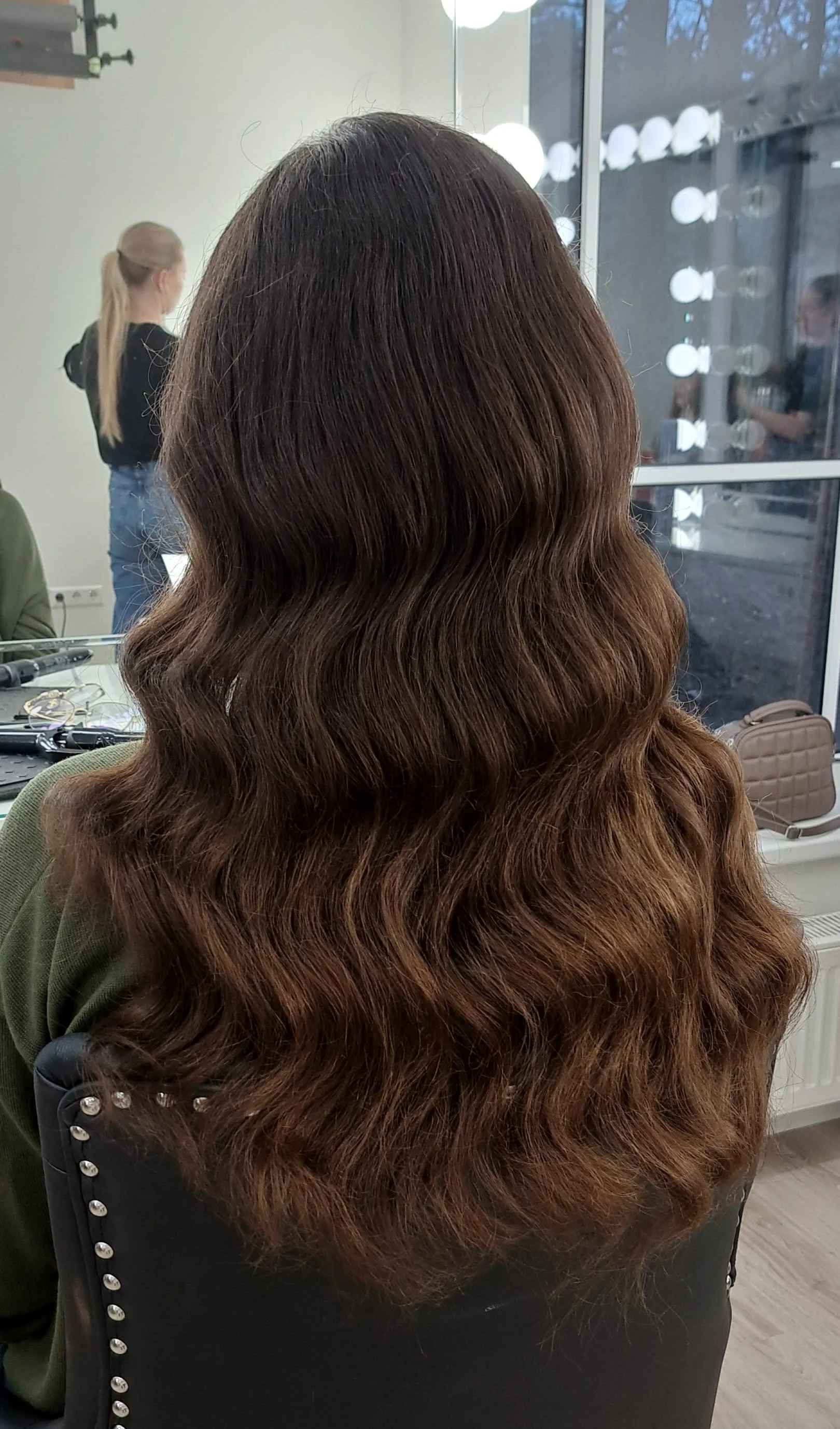 Vidutinio ilgio banguotų plaukų kirpimas salone „Edita“.