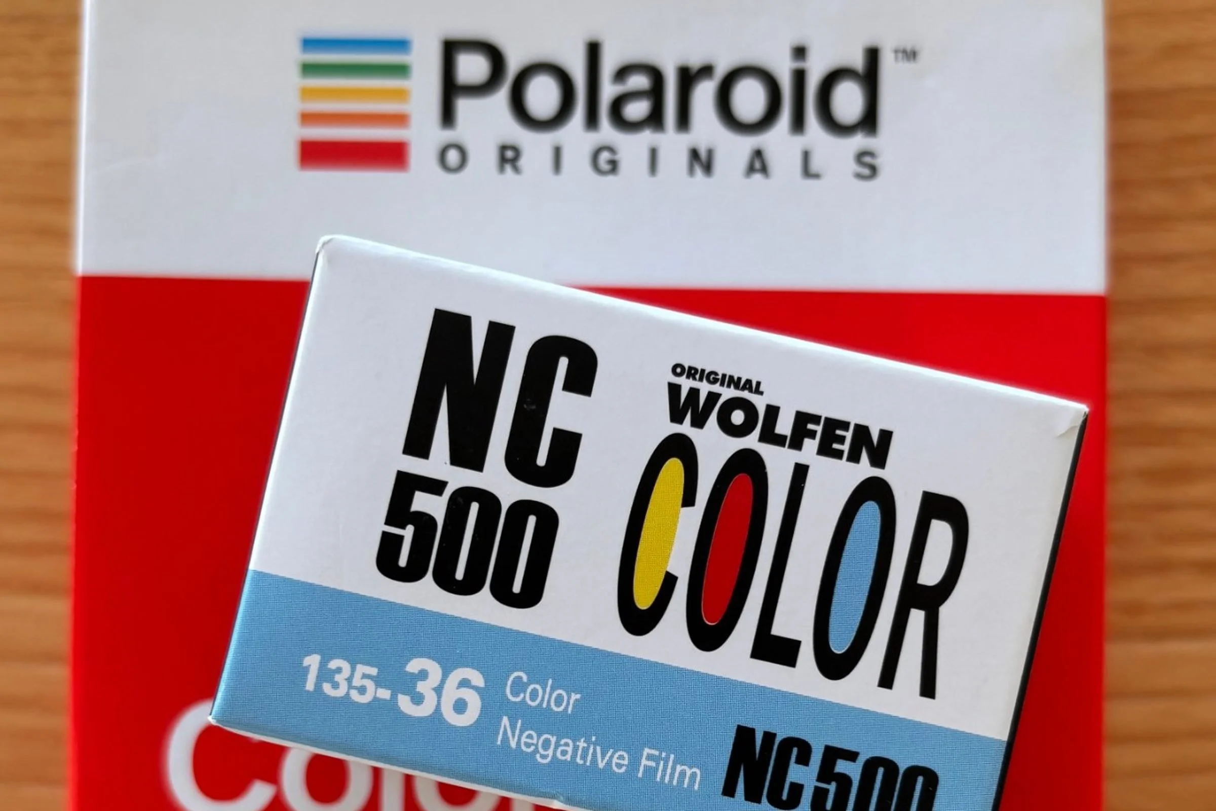 Packung Original Wolfen NC500 Kleinbildfilm liegt auf einer Packung Polaroid SX-70 Farbfilm