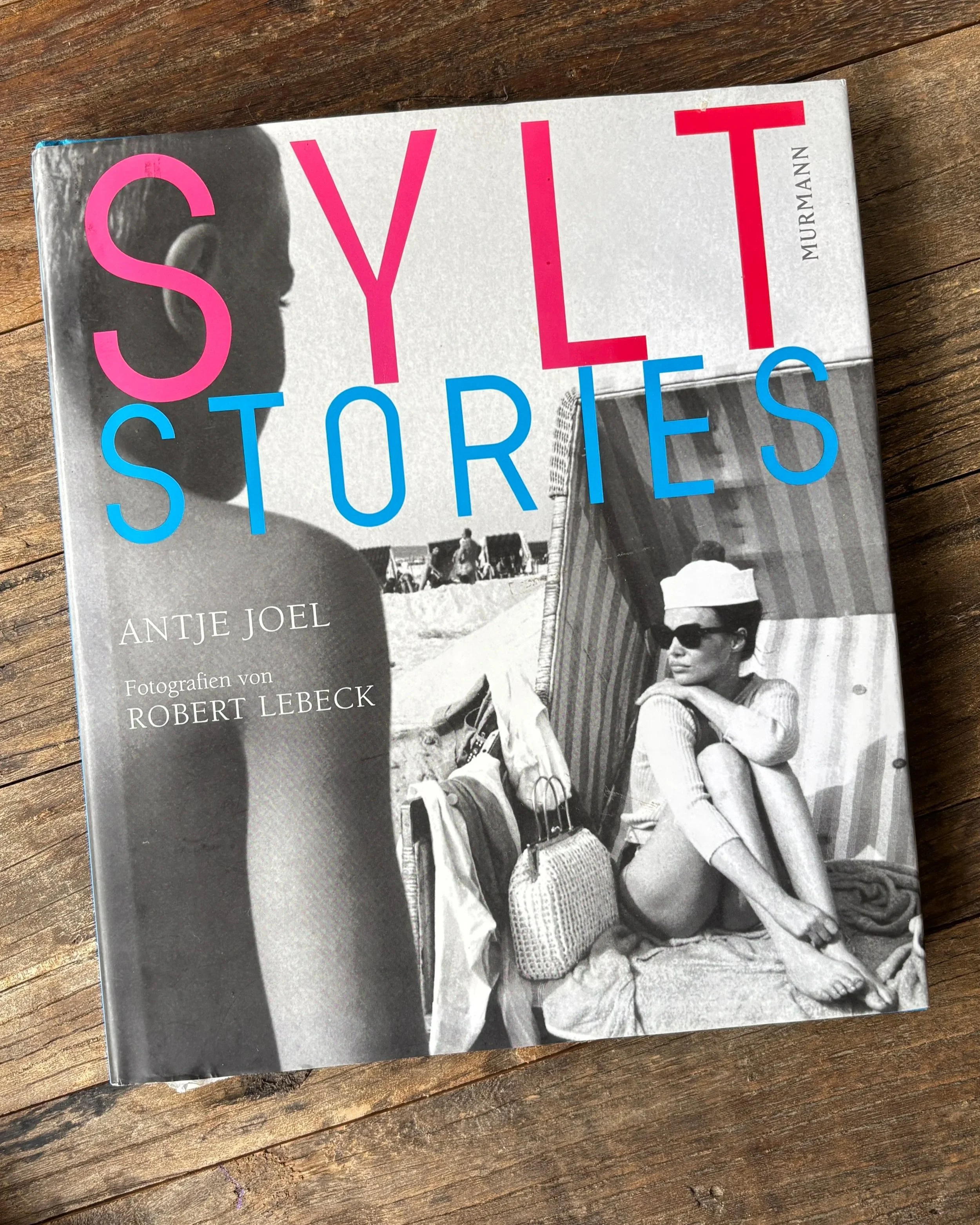 Das Buch Sylt Stories liegt auf einem Holztisch