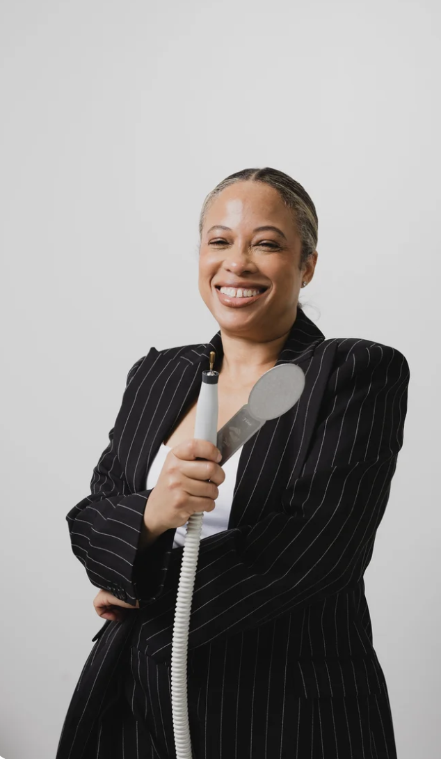 Owner of Neaten Nail Bar smiling in a black blazer.