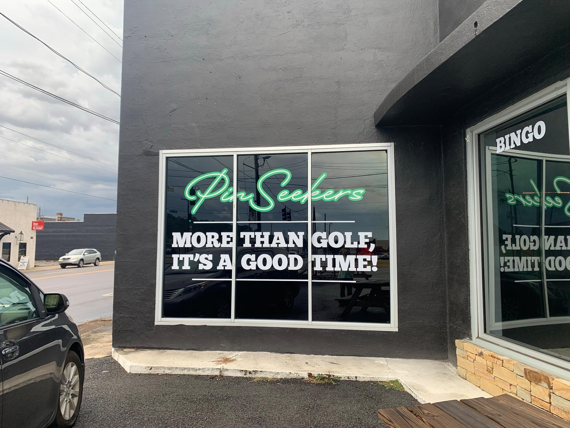 Sign on a building window reads: "Pin Seekers more than golf, it's a good time!"