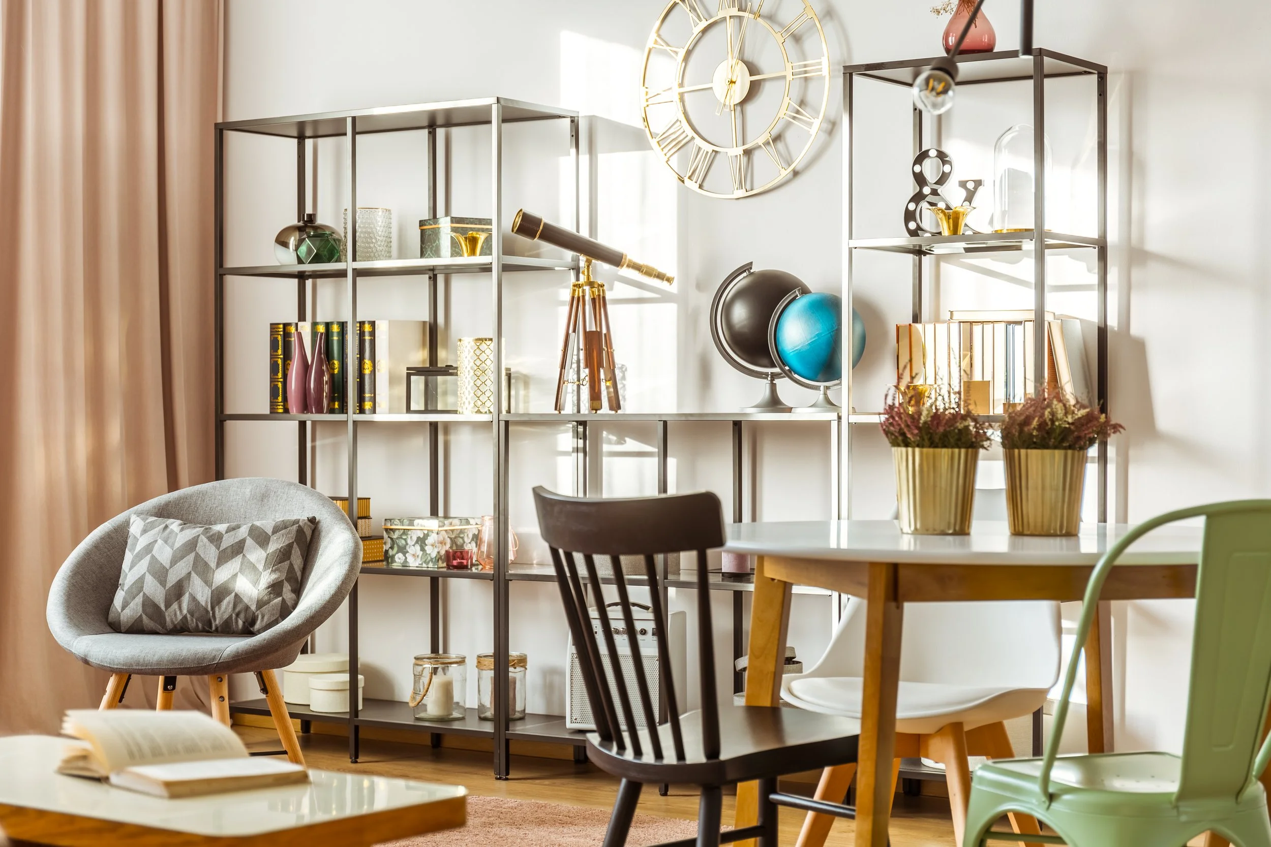 Interior of a living room with shelves, decorative items, and a table with potted plants.