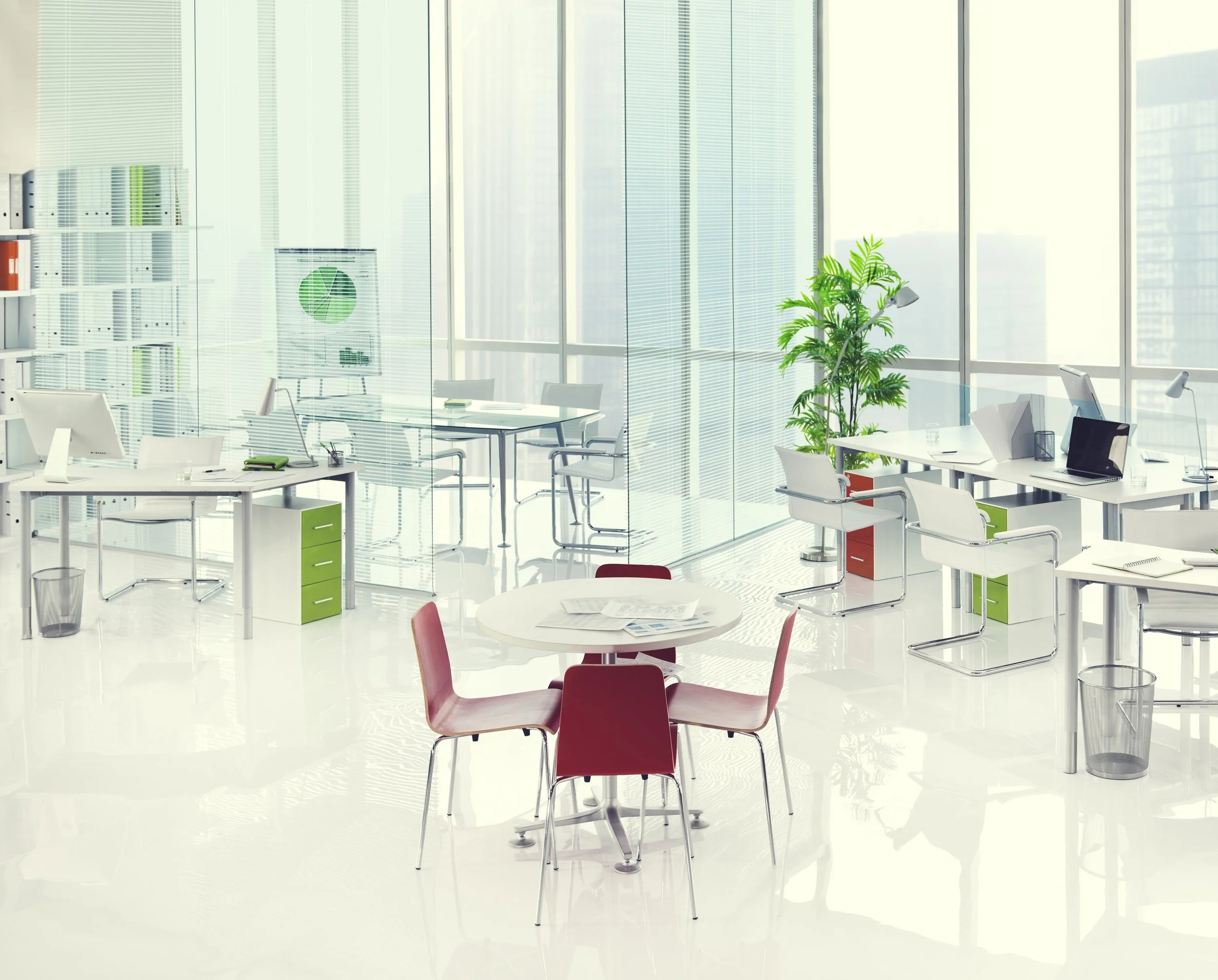 Modern, bright office space with white desks, chairs, large windows, potted plant, and minimal clutter.