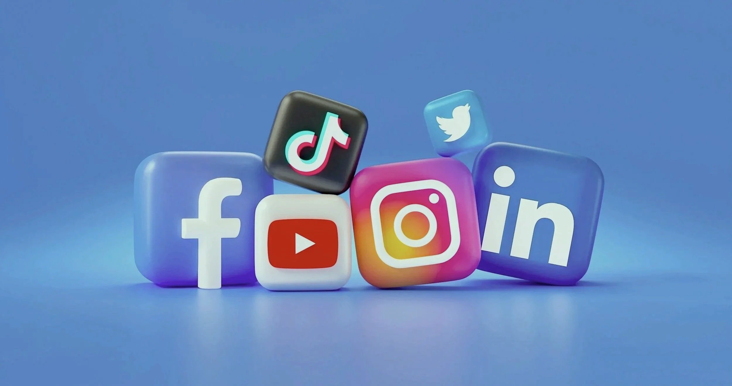 Social media icons for Facebook, YouTube, TikTok, Instagram, Twitter, and LinkedIn on colorful glass-like cubes against a blue background.