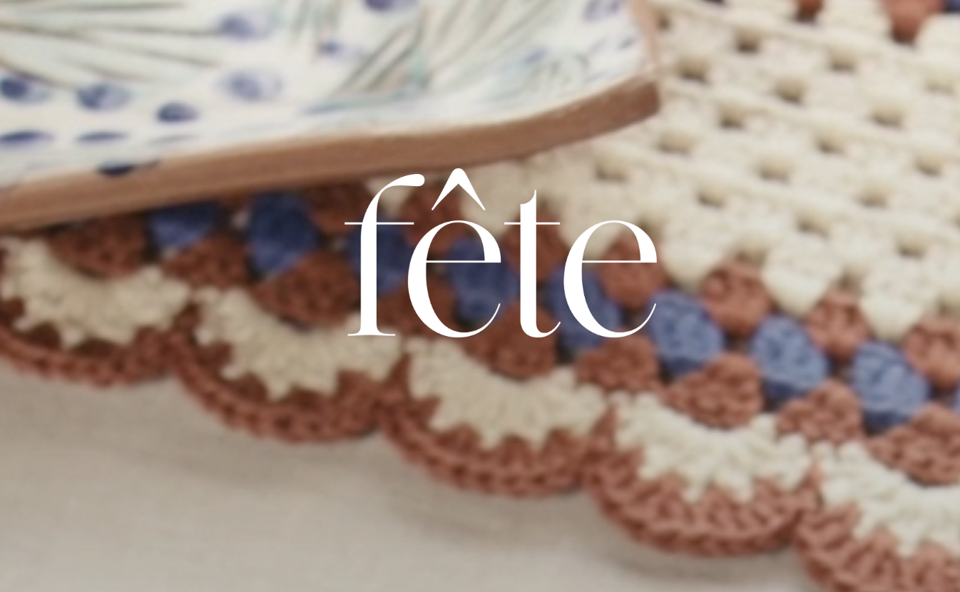 A decorative crocheted table runner with stars in red, white, and blue colors, with a stack of cash on top, partially visible. The logo "FETE" in white.
