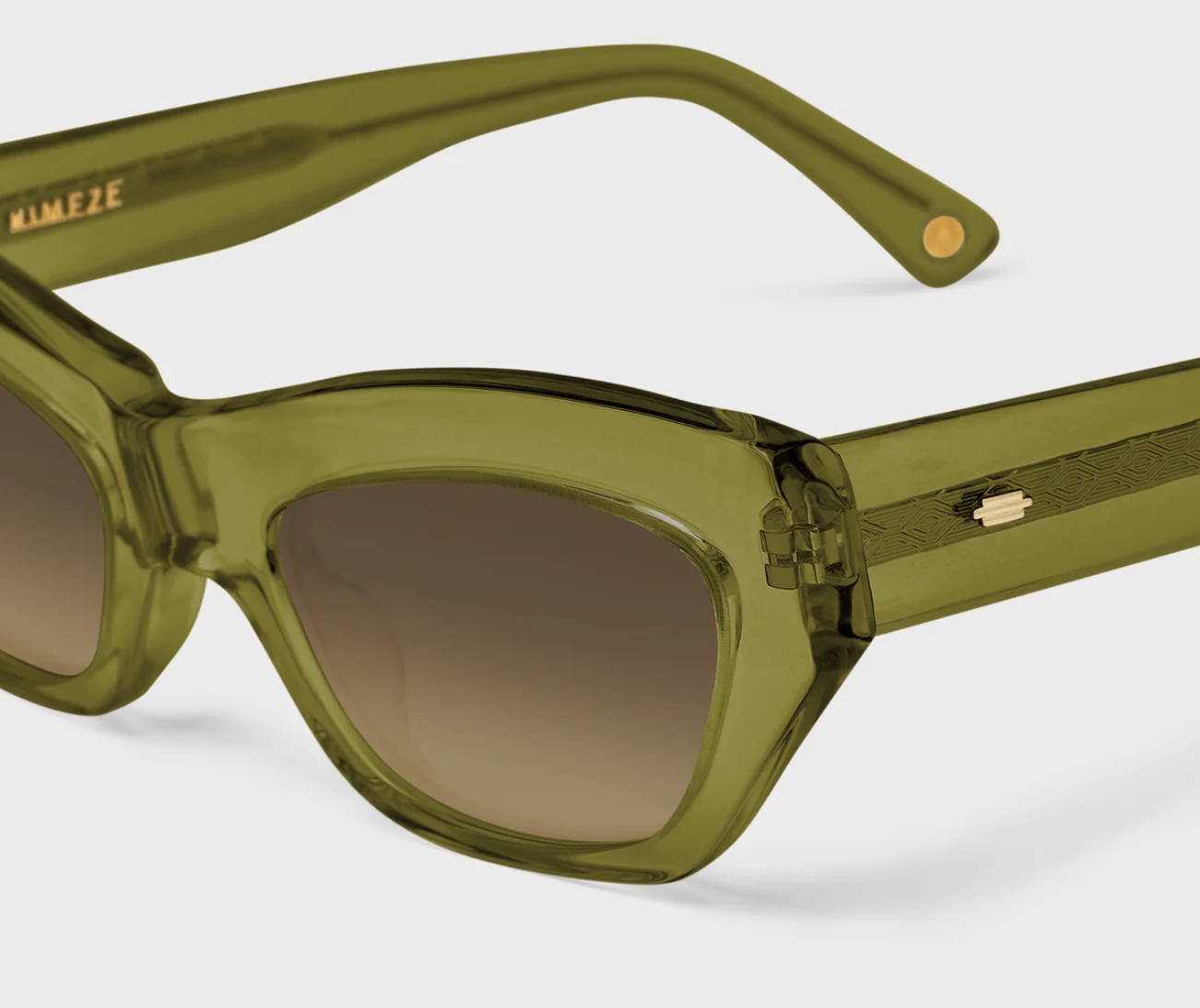 Close-up of green, semi-transparent sunglasses with brown tinted lenses on a white background with a KIMEZE logo inside.