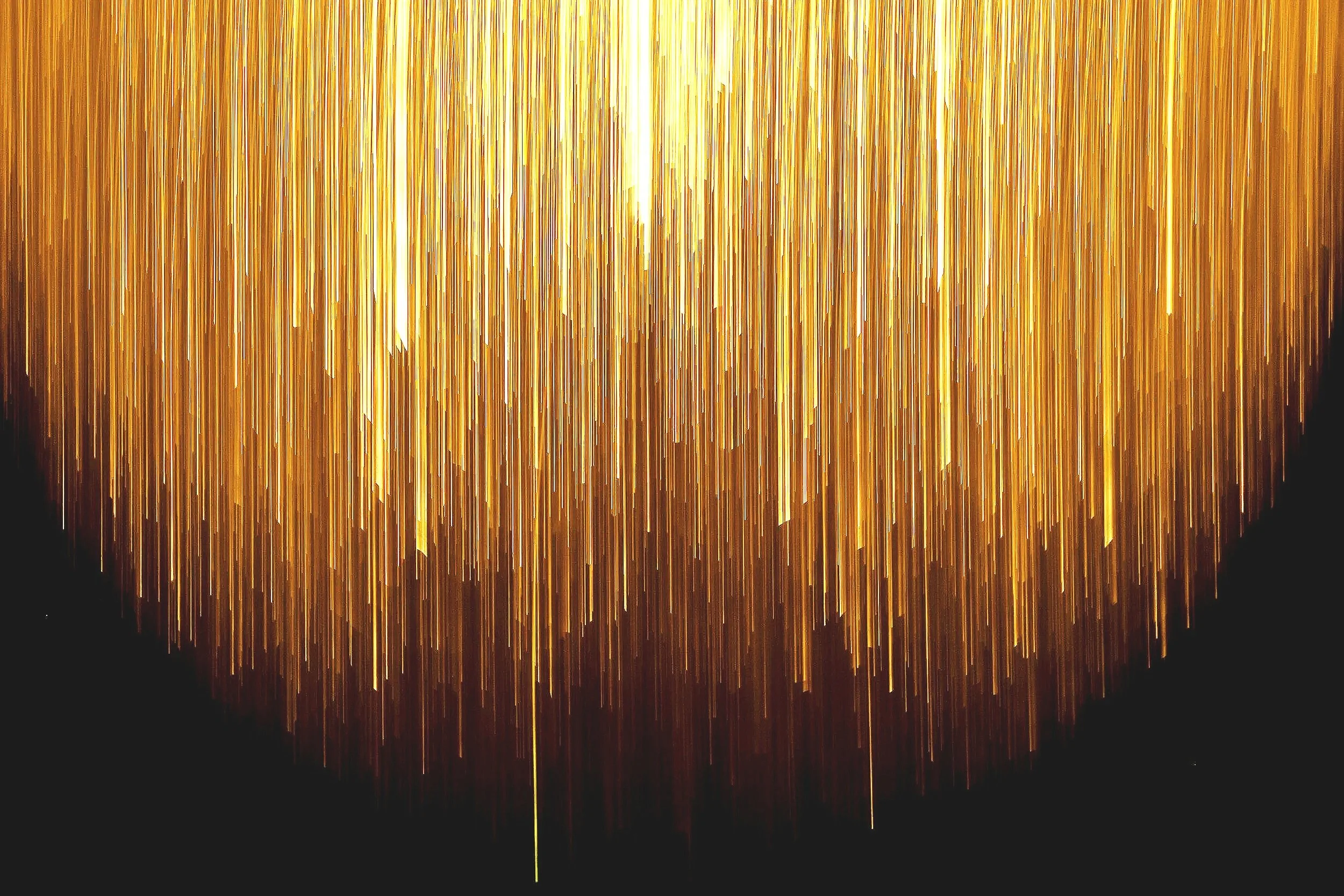Gold-colored sparkling streamers hanging against a black background.