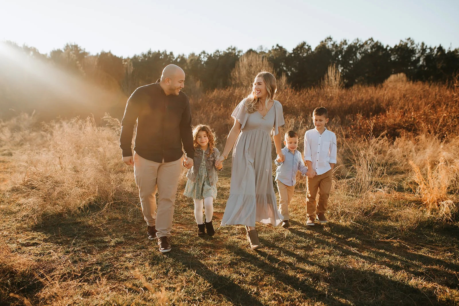 a family in a field in flowery branch georgia takes photos at sunset