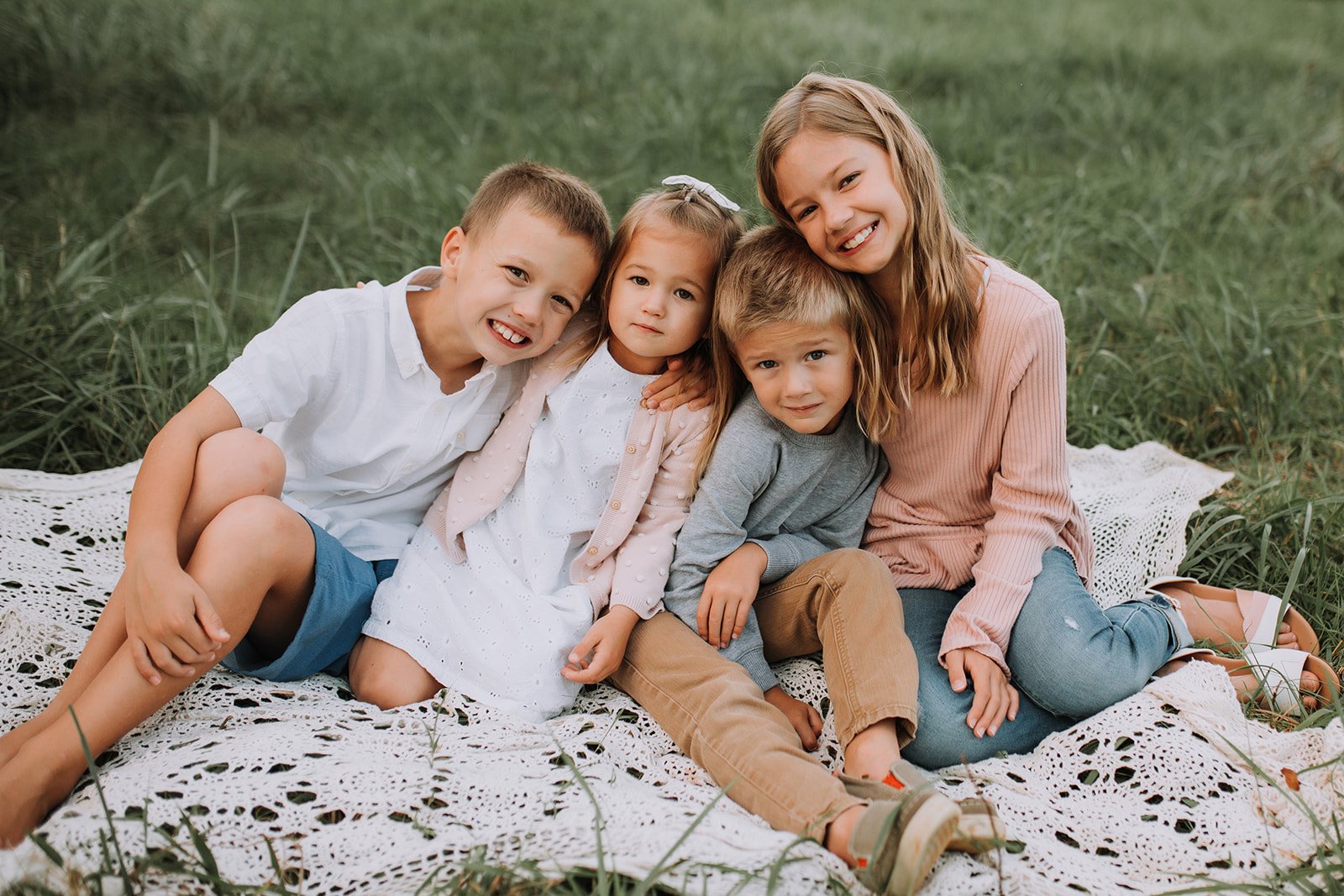 Kids sitting together in a field in suwanee georgia for family photos