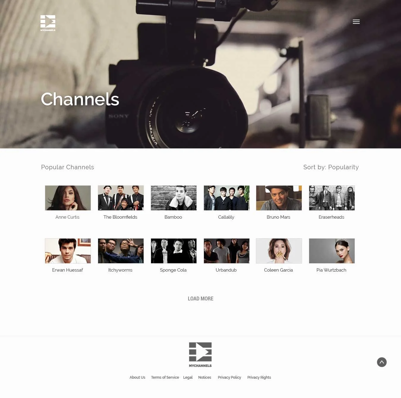 Homepage of a video channel website showcasing a camera in the background with a list of popular channels including Anne Curtis, The Bloomfields, Bamboo, Callality, Bruno Mars, Eraserheads, Erwan Huessaf, Itchyworms, Sponge Cola, Urbandub, Coleen Garcia, and Pia Wurtzbach.