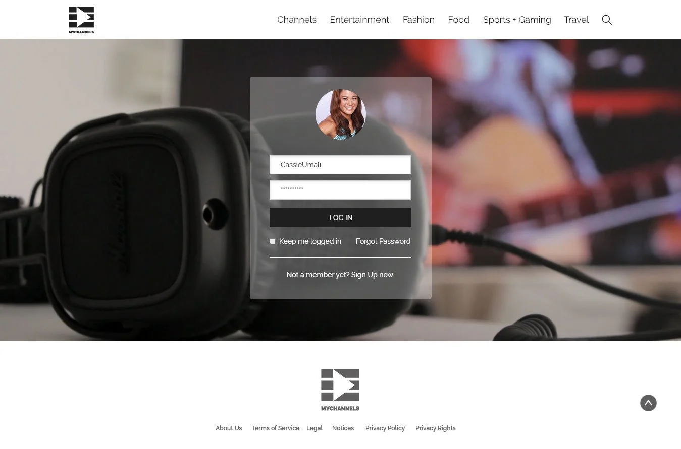 Login page of MYCHANNELS website with a background image of a black headphone and a blurred background of a person playing a guitar.