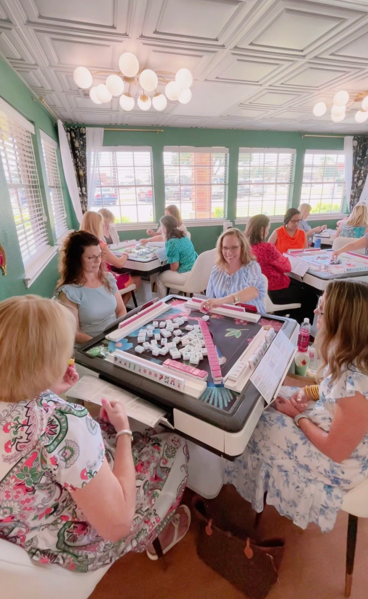 women playing mahjong on an automatic mahjong table