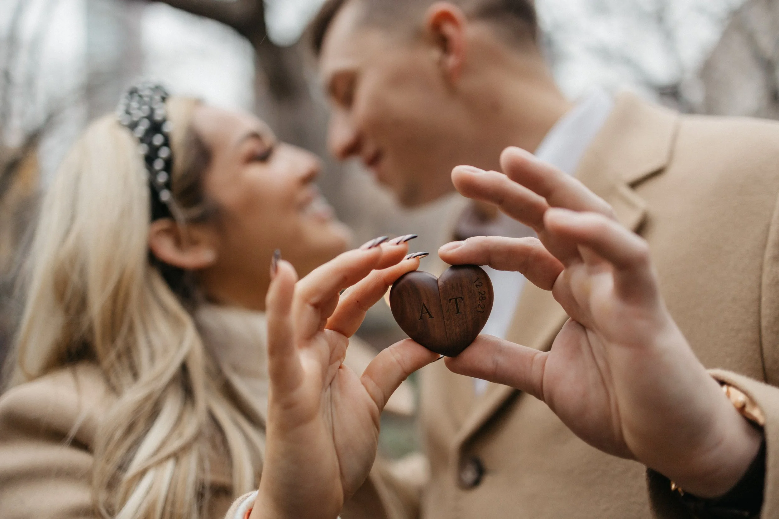 A couple holding a wooden heart with engraved initials. Manhattan, New York City Engagement session.