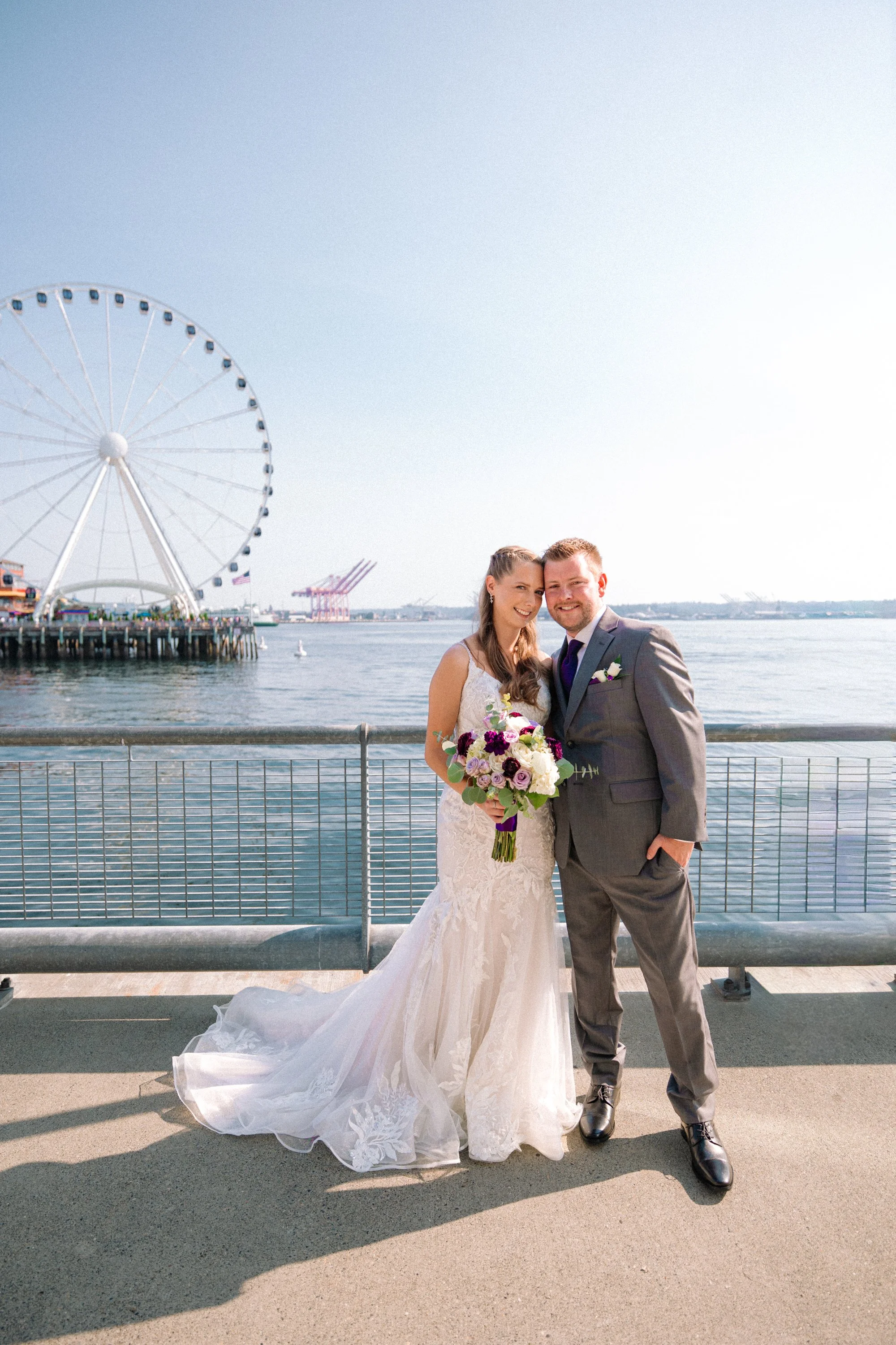 Wedding couple portrait on the Seattle waterfront with the Seattle Great Wheel in the background.