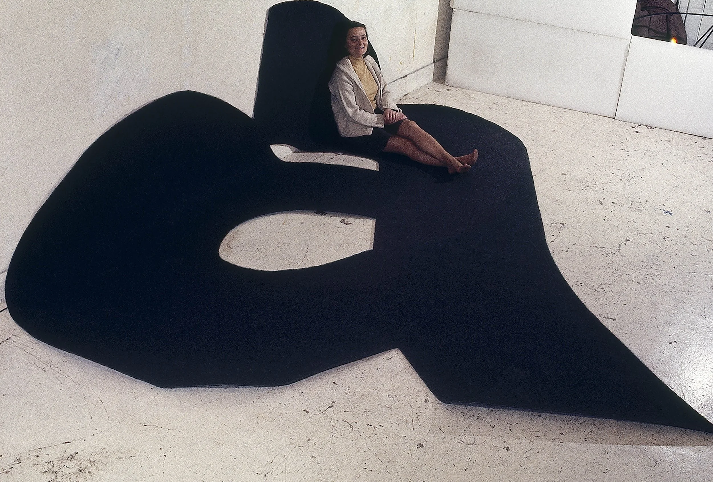Mary Ann Melchert sitting on Rugged a, 1970, black carpet