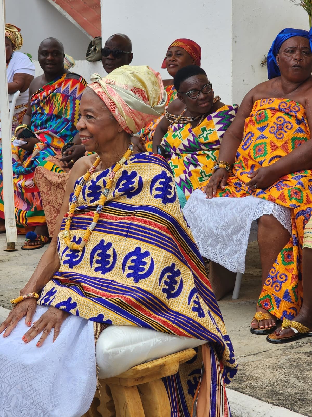 A group of women dressed in traditional colorful African attire attending a cultural event or celebration.