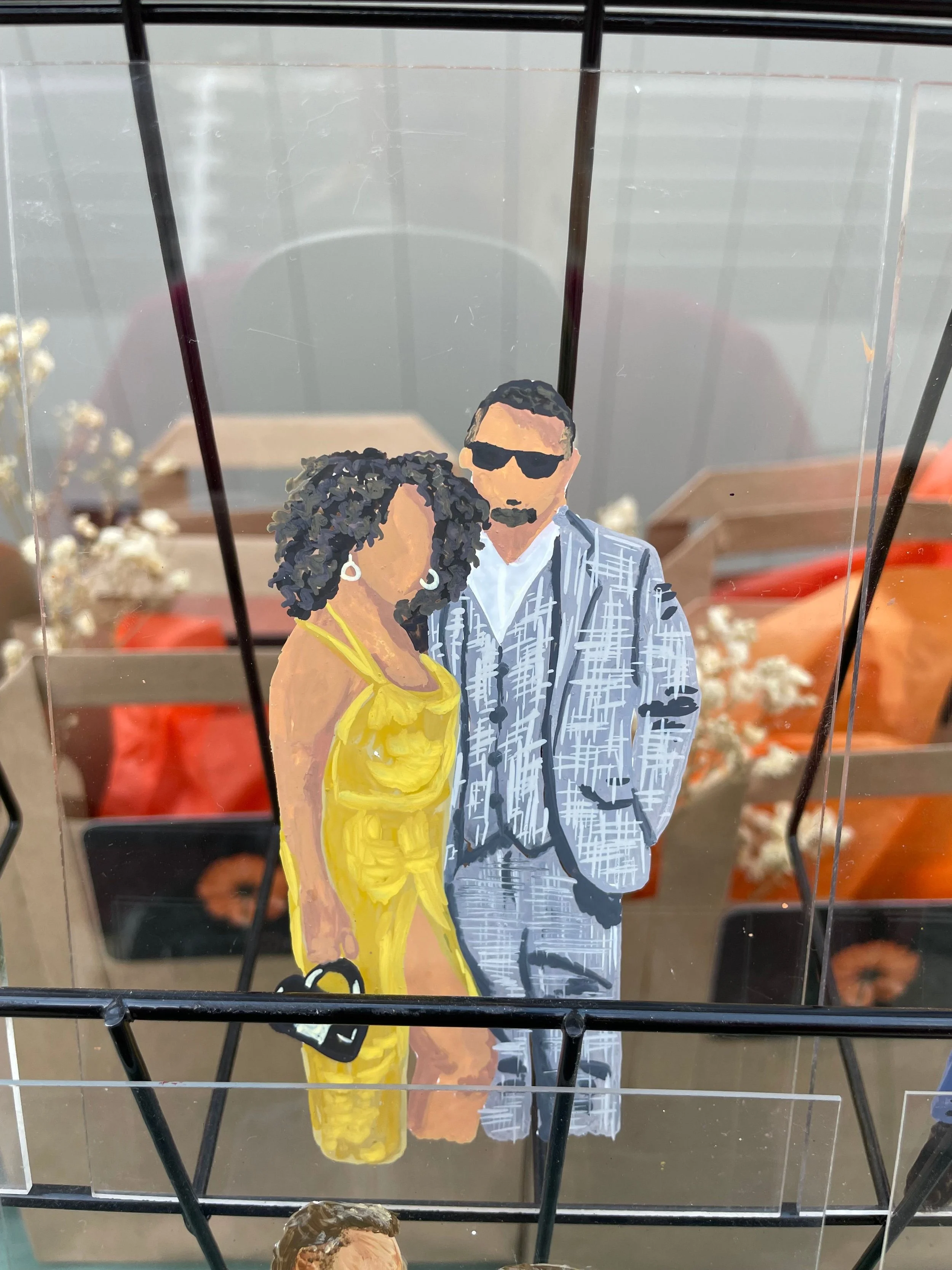 Hand-painted illustration of a man and woman dressed stylishly, with the man wearing sunglasses and a patterned suit, and the woman in a bright yellow dress, holding a purse.