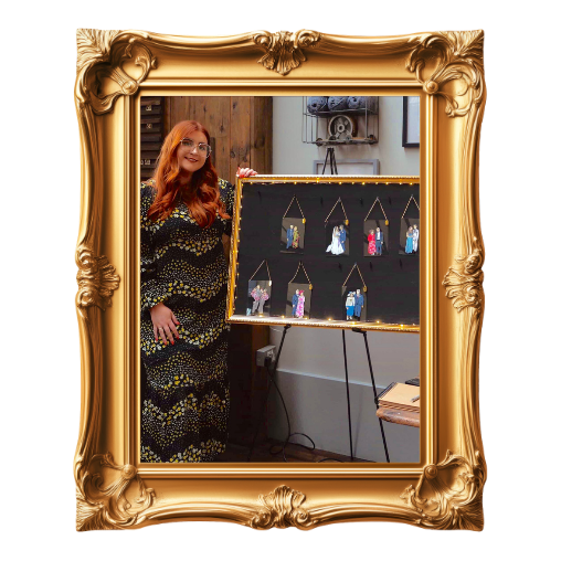 Woman with long red hair and glasses standing next to a display board showing live wedding illustrations