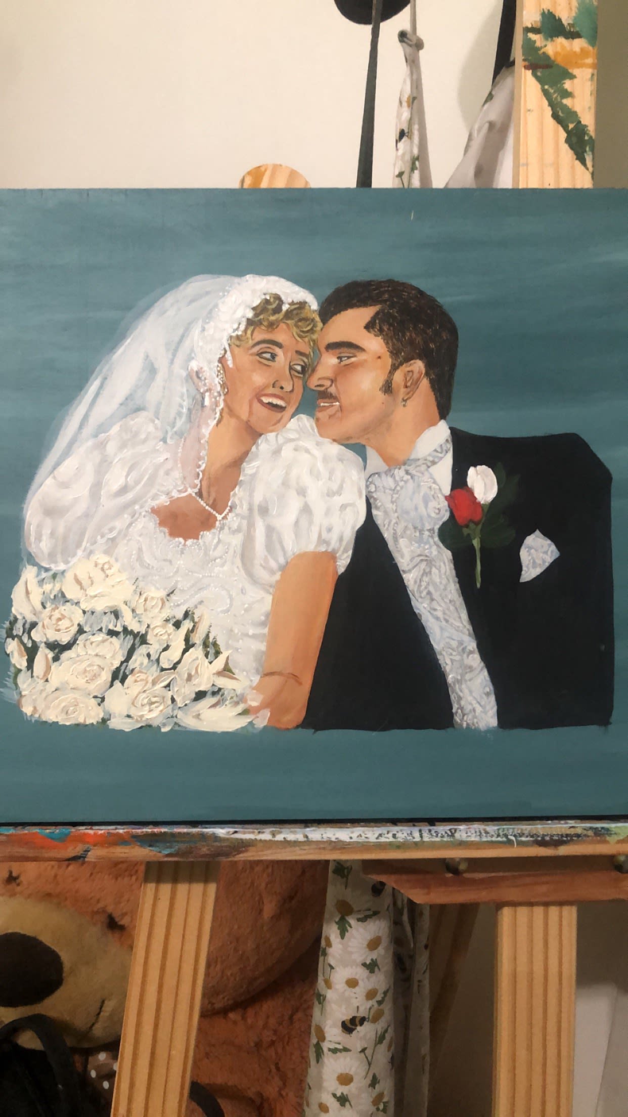Painting of a bride and groom on their wedding day, looking at each other, with the bride holding a bouquet of white roses.
