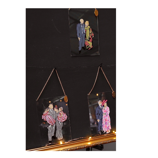 Three wedding guest illustrations of couples dressed in vintage clothing hanging on a black wall