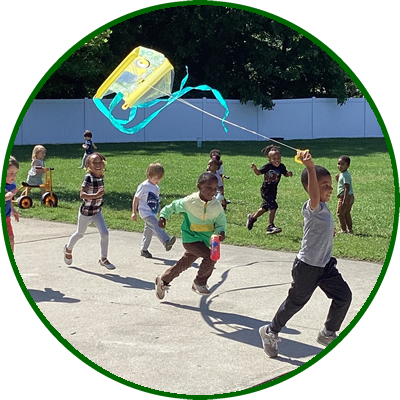 Children playing outdoors with a kite on a sunny day.