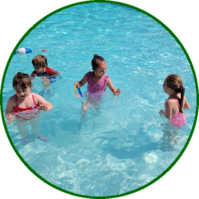 Three young girls playing and swimming in a pool.