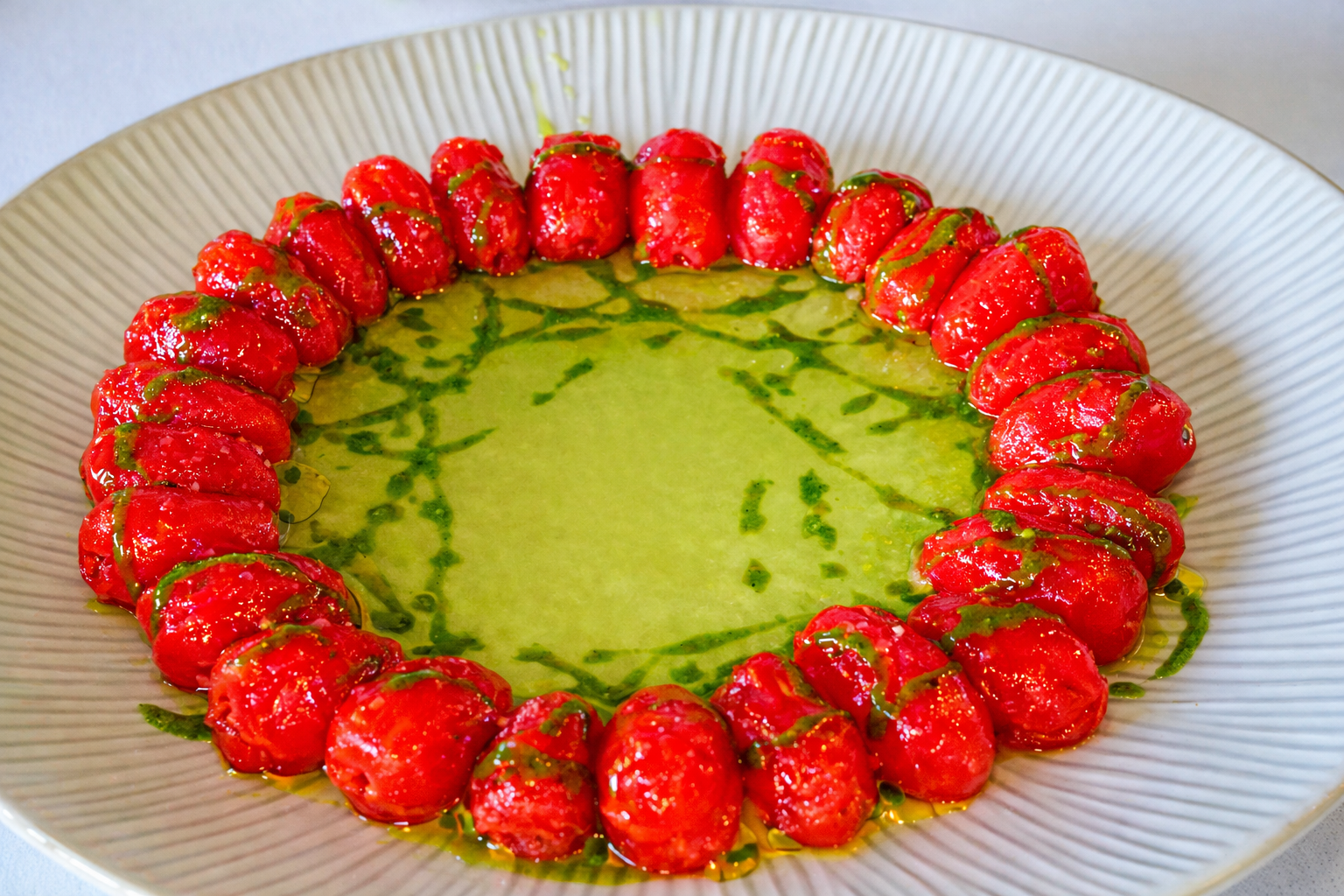 Tomates sobre agua de tomate y albahaca